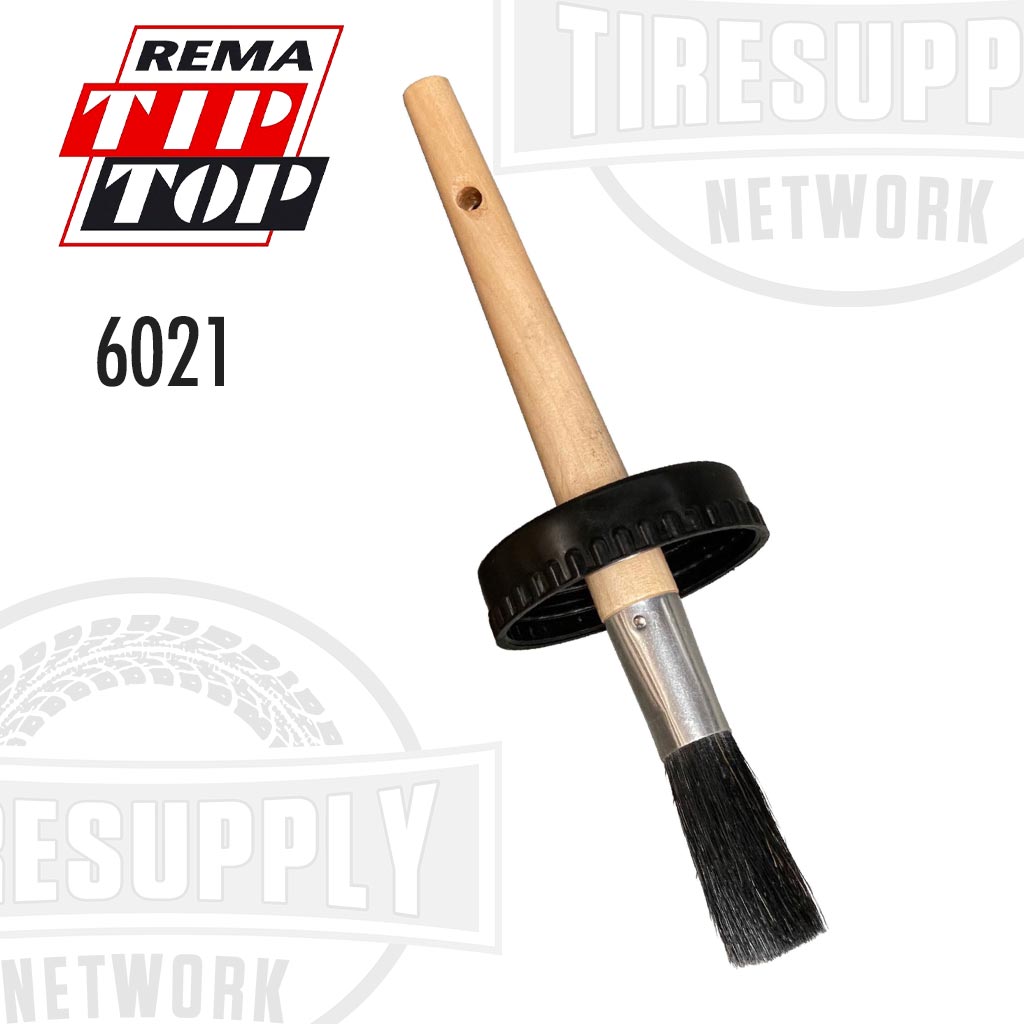 A black brush with a wooden handle, presumably for applying cement, with the Rema Tip Top brand logo and the number 6021 visible.