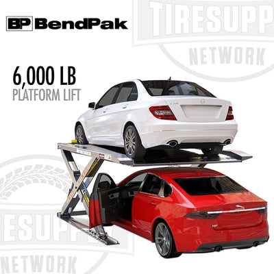 A BendPak 6,000 lb platform lift with a white car on the lift and a red car below it, showcasing the lift's capacity and design.