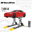 Red car on a BendPak SPX-7XE car lift with 'BP BendPak' and 'Tiresup Network' branding.