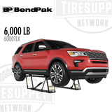 Red SUV on a BendPak tire changer with 'BP BendPak' and 'Tiresup Network' branding. 6000TLX