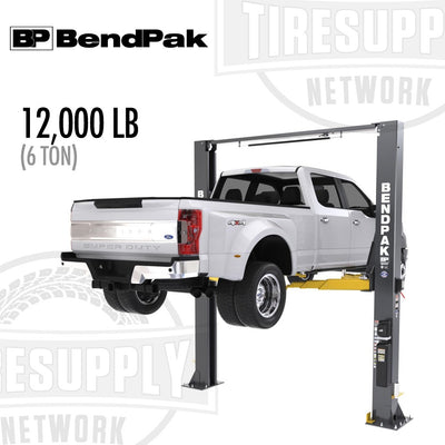 A BendPak 2-Post Lift with a 12,000 lb capacity, clearfloor design, and screw pads, in gray and yellow colors, lifting a white vehicle.