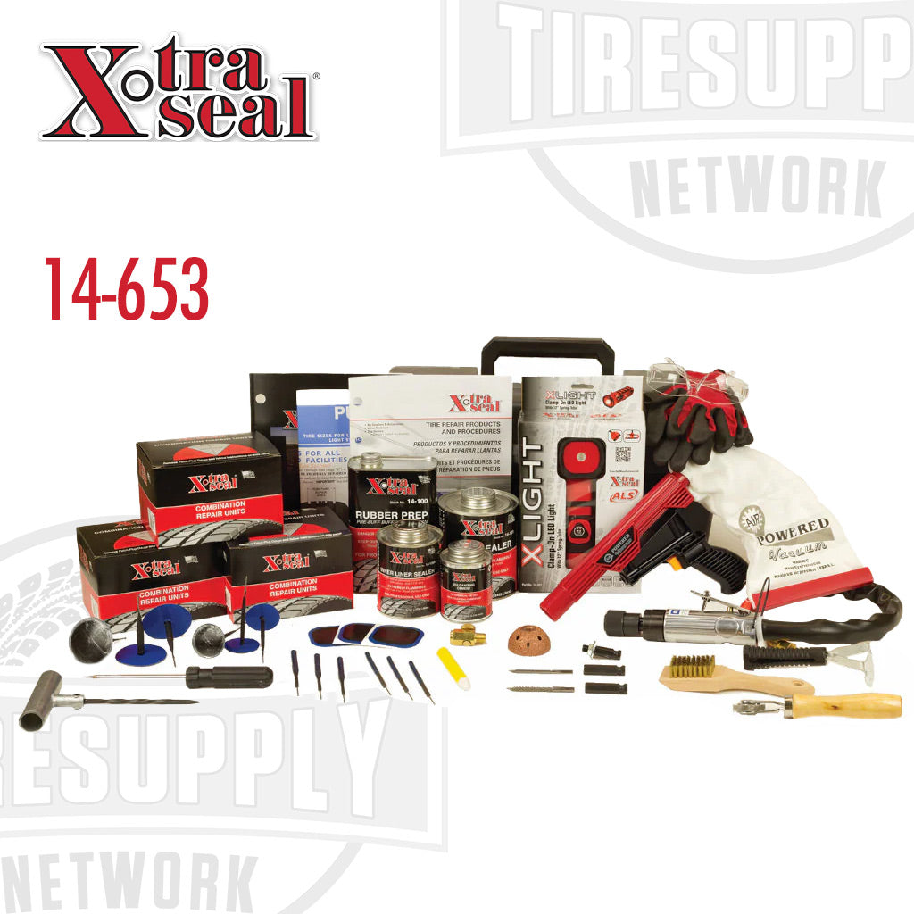 A collection of various tire repair tools and materials displayed on a table, including patches, cement, brushes, and a toolbox. 14-653